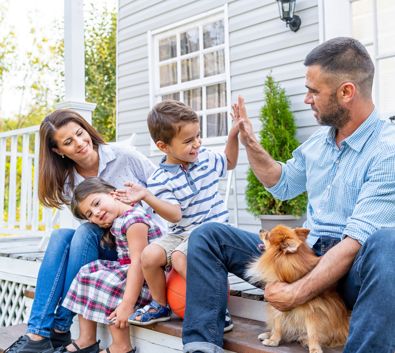 family-sitting-on-front-porch-deck